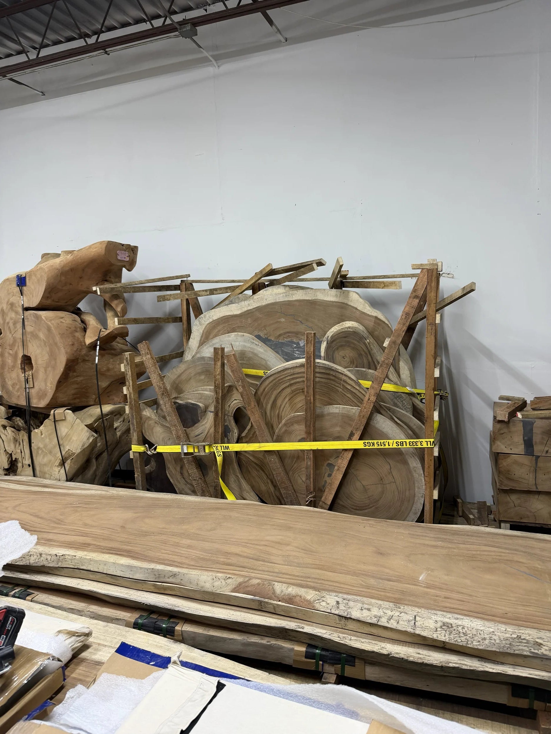 Stack of wooden panels with a measuring tape on a white wall